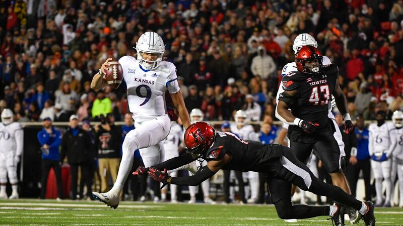 Kansas quarterback Jason Bean (9) runs the ball against Texas Tech defensive back Rayshad...