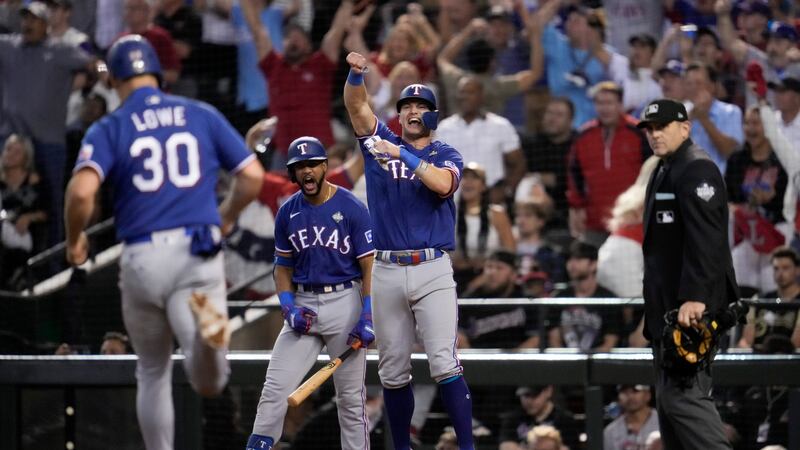 Texas Rangers' Josh Jung and Nathaniel Lowe (30) celebrates after scoring on a single by Jonah...