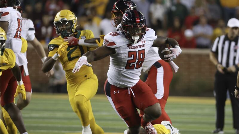Texas Tech running back Tahj Brooks (28) slips past Baylor linebacker Josh White, bottom...