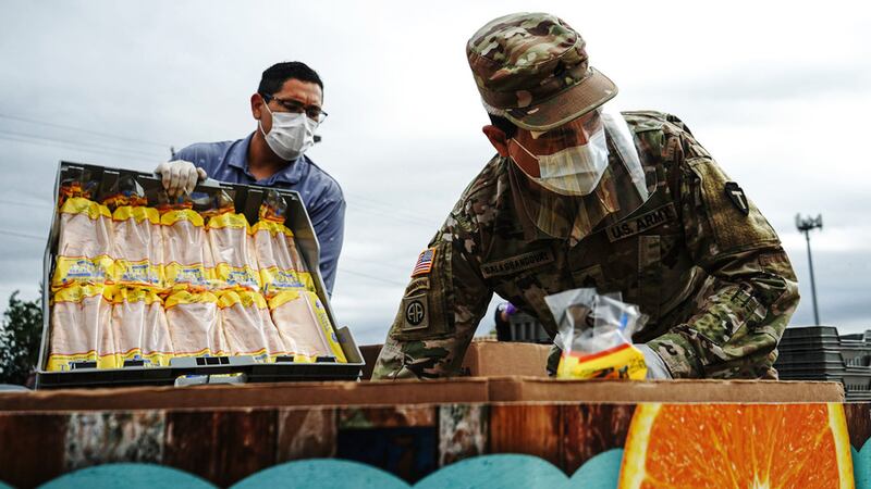 Texas Army National Guard Staff Sgt. Juan Salas helps to organize bread at the Food Bank of...